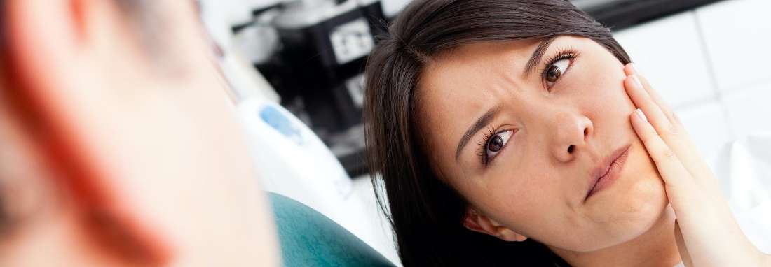 woman holding jaw from tooth pain in Havertown